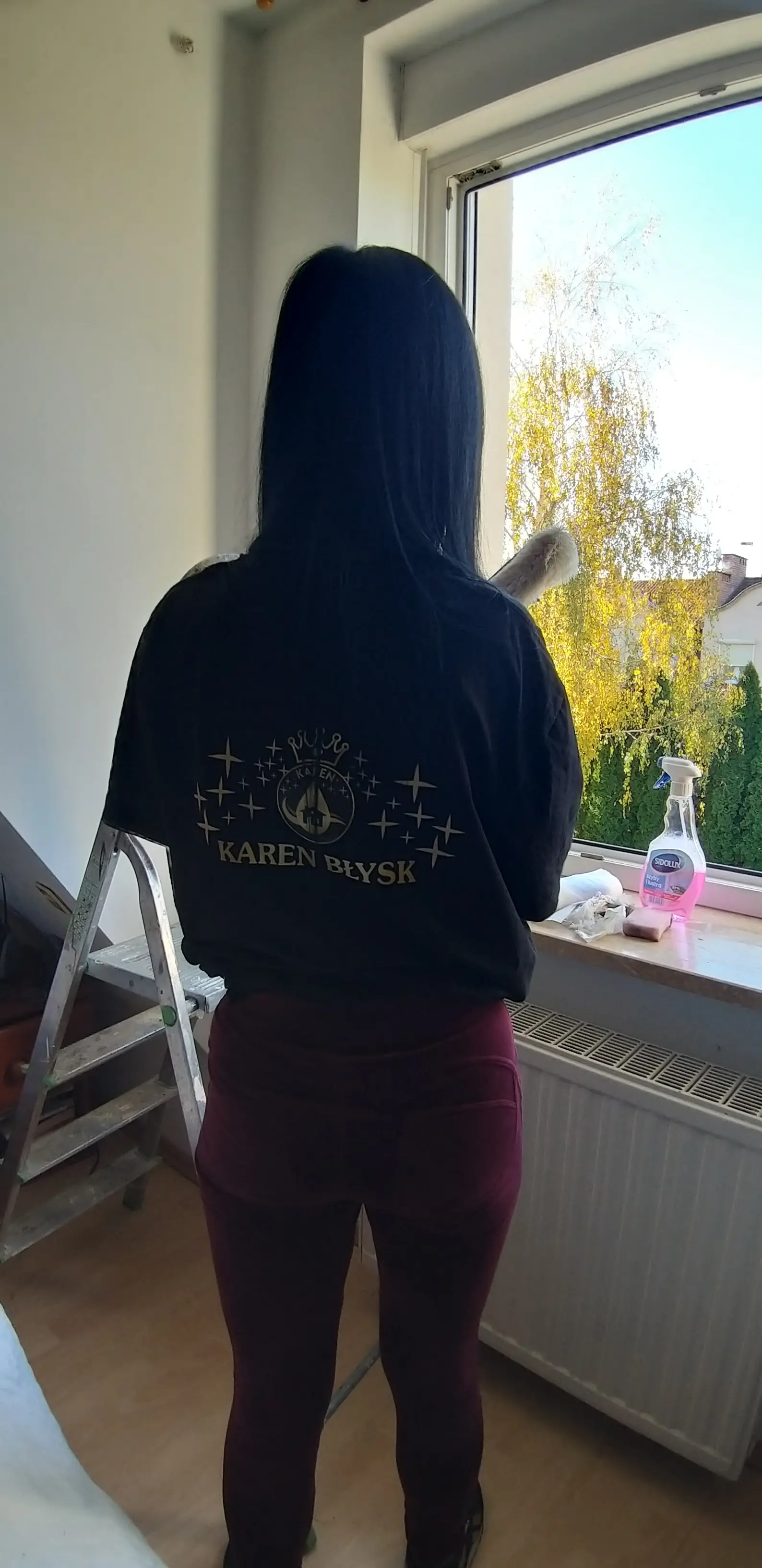 Sprzątaczka przygotowująca się do mycia okna w mieszkaniu – dokładne mycie szyb przez firmę sprzątającą Karen Błysk